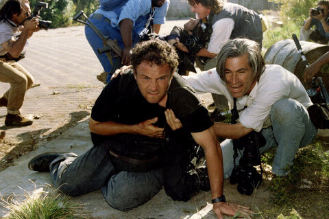 گرگ مارینوویچ، عکاس اهل آفریقای جنوبی (چپ)، که برای مجله نیوزویک کار می‌کند، پس از اصابت گلوله به سینه‌اش در شهرک توکوزا، شرق ژوهانسبورگ، در ۱۸ آوریل ۱۹۹۴، توسط همکار آمریکایی‌اش جیم نچوی (راست) نجات داده