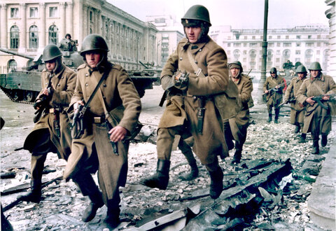 سربازان در جریان تیراندازی متقابل بین نیروهای طرفدار چائوشسکو و هواداران ضد رژیم در نزدیکی میدان جمهوری در بخارست، رومانی، به دنبال پناهگاه می‌دوند، ۲۴ دسامبر ۱۹۸۹.