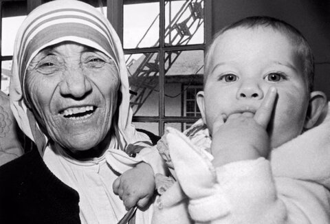 مادر ترزا، برنده جایزه صلح نوبل، کریستینا اوت، کودک نه ماهه اهل سوئیس را طی مراسمی در هنگ کنگ در آغوش گرفته است، ۱۶ ژانویه ۱۹۸۵