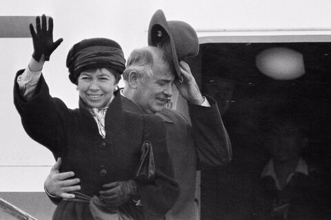 میخائیل گورباچف، رهبر اتحاد جماهیر شوروی، کلاه و کمر همسرش رایسا را ​​محکم گرفته است،